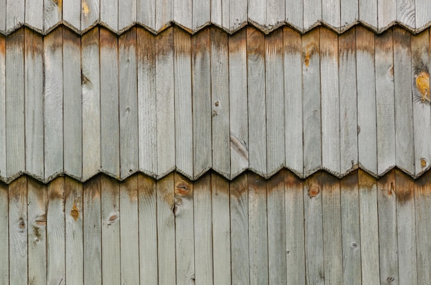 Een fragment van een houten hek gemaakt van dunne oude planken.