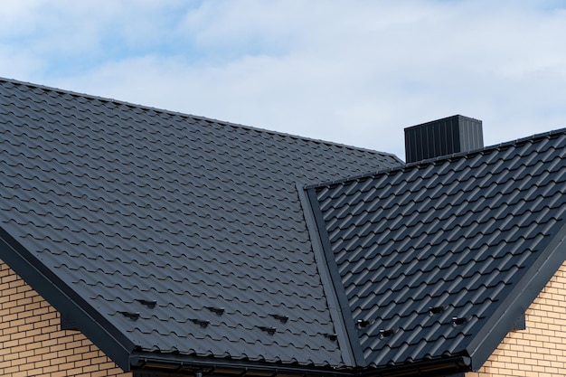 Een fragment van het dak gemaakt van metalen dakpannen Modern metalen dak Huis dakconstructie