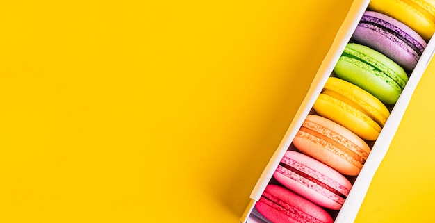 Een Franse zoete delicatesse, makarons verscheidenheid close-up. Kleurrijke Franse Makarons in vakje op de moderne mening van de lijstbovenkant met copyspace