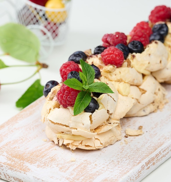 Een gebakken cake gemaakt van geklopte kippeneiwit en room gedecoreerd met verse bessen Dessert Pavlova