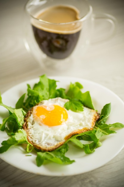 Een gebakken ei met rucola en sla in een bord