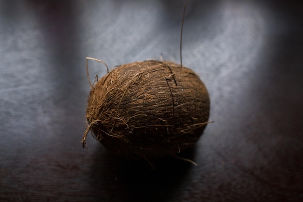 Een gebarsten kokosnoot ligt op een donkere tafel