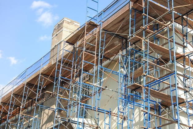 Een gebouw in aanbouw met steigers en een ladder op de top.