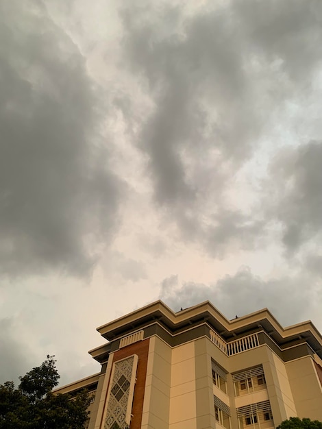 Foto een gebouw met een bewolkte lucht op de achtergrond