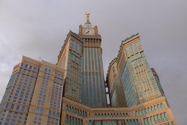 Een gebouw met een klok erop waarop de naam makkah staat zamzam-toren in de buurt van de grote moskee van mekka