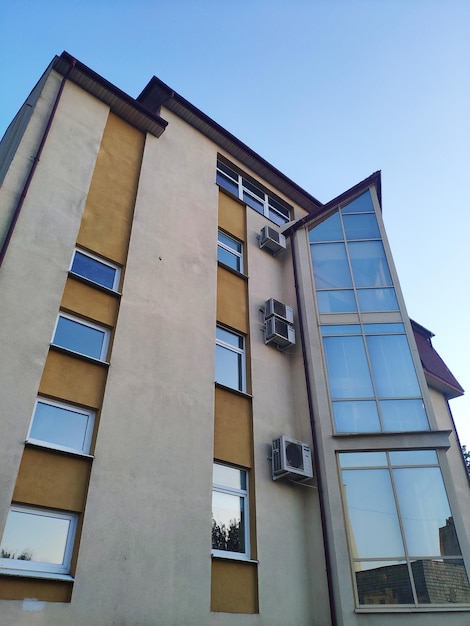 Een gebouw met veel ramen en airconditioners op de top.