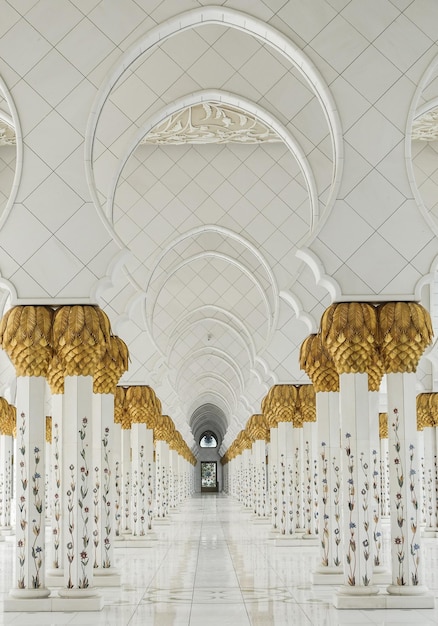 Een gebouw met zuilen en gouden decoraties aan het plafond