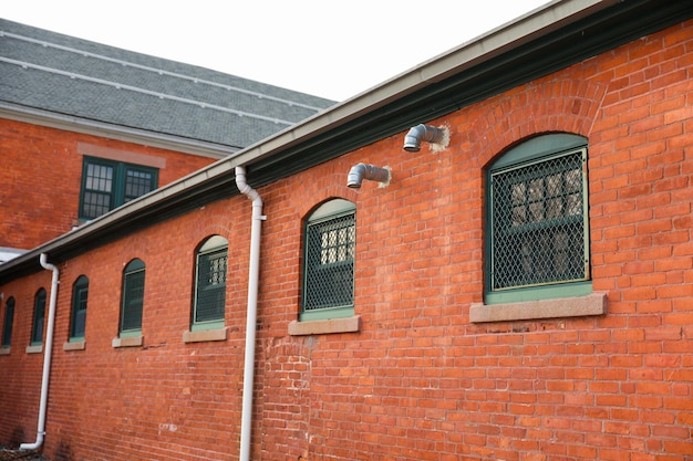 Een gebouw van rode baksteen met een groen raster boven de ramen.