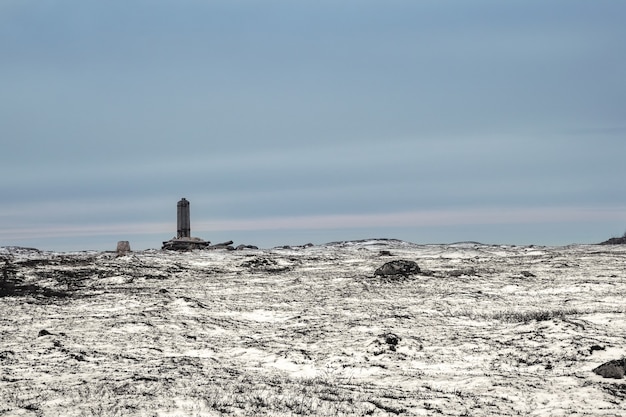 Een gebroken telegraafpaal op een met sneeuw bedekte Arctische heuvel