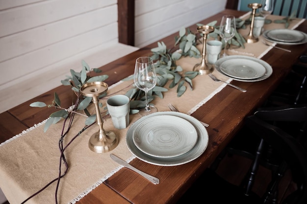 Een gedekte tafel voor een bruiloft met een bladgouden loper en een wit bord met het woord varen erop.