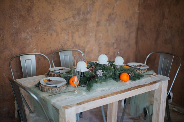 Een gedekte tafel voor een kerstdiner met sinaasappels en dennenappels