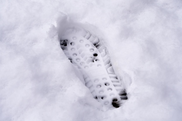 Een gedetailleerde afdruk van een enkele schoen afdruk in verse sneeuw