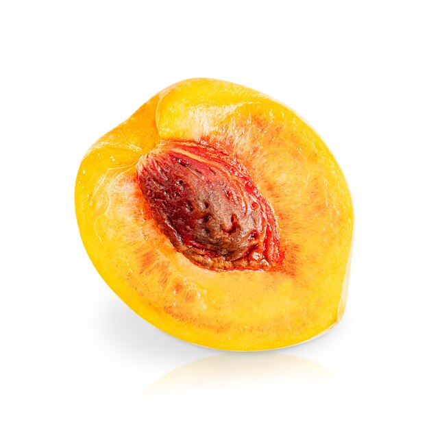 Een gehalveerd sappig perzik tropisch fruit van oranje kleur met bruine pit geïsoleerd op wit