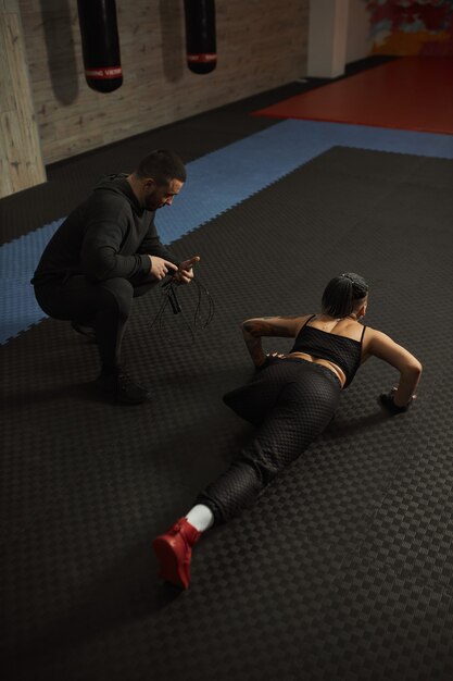 Een gehandicapt meisje is bezig met de sportschool een vrouw met één been traint met een trainer, ze werkt hard en geeft niet op voor problemen