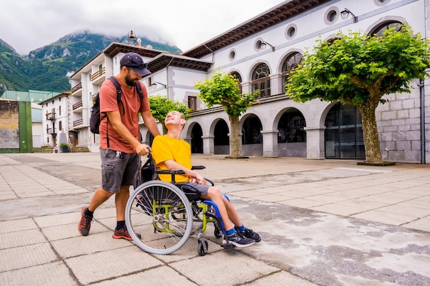 Een gehandicapte in een rolstoel die door het dorpsplein loopt en plezier heeft met een vriend