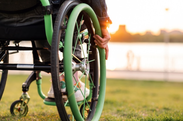 Een gehandicapte man zit in een rolstoel hij houdt zijn handen aan het stuur foto van hoge kwaliteit