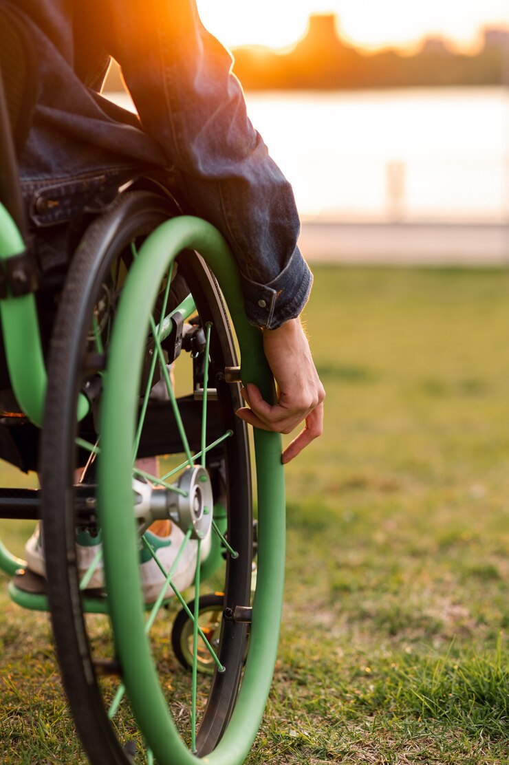 Foto een gehandicapte man zit in een rolstoel hij houdt zijn handen aan het stuur foto van hoge kwaliteit