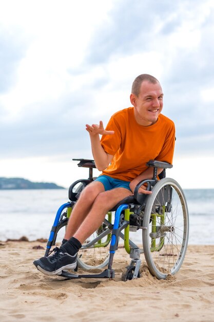 Een gehandicapte persoon in een rolstoel op het strand in de zomer lacht