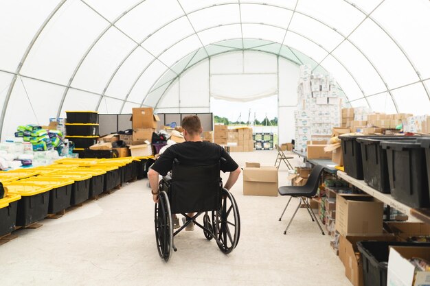 Foto een gehandicapte veteraan in een rolstoel helpt bij een humanitaire eenheid ter ondersteuning van oorlogsslachtoffers