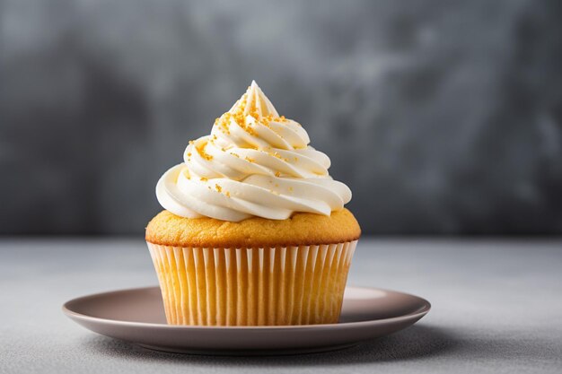 Een gele bord met heerlijke romige cupcake op een grijs oppervlak