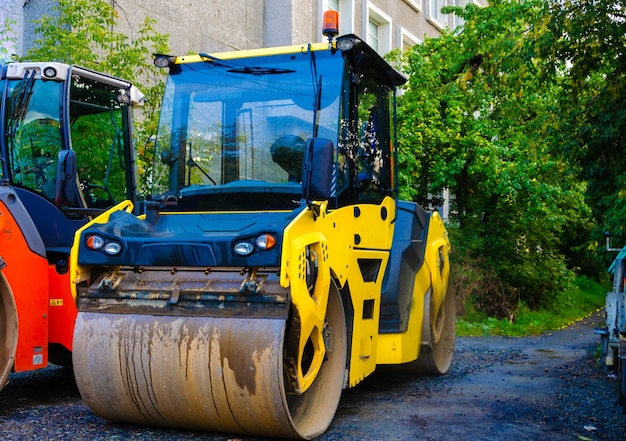 Foto een gele en zwarte bulldozer staat op een onverharde weg.