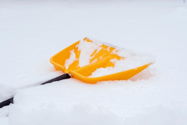 Een gele schop liggend in de sneeuw