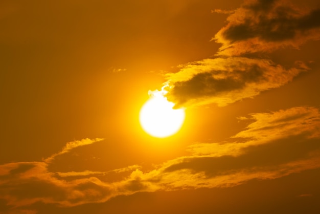 Een gele zon brandt terwijl de zon ondergaat aan de hemel.