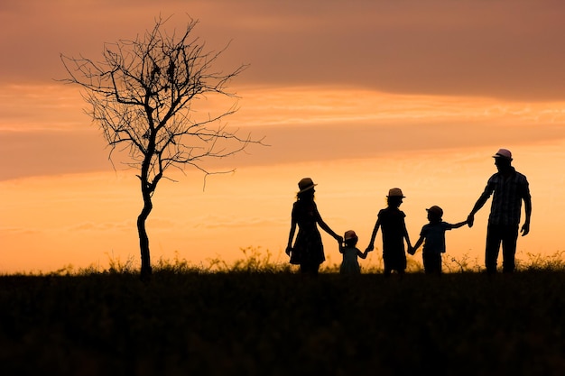 Een gelukkig familiesilhouet op aard in parkachtergrond