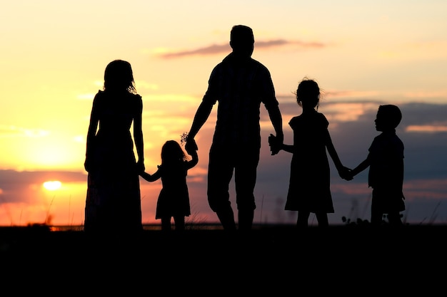 Een gelukkig familiesilhouet op zee met weerspiegeling in het park in de natuur