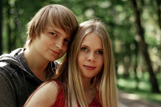 Foto een gelukkig getrouwd stel echtgenoot knuffelt een mooie volwassen vrouw. wandelingen in een park.