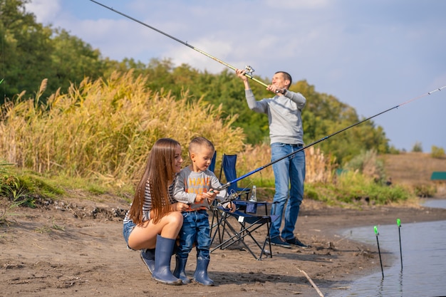 Een gelukkig gezin brengt samen tijd door, ze leren hun zoon vissen.
