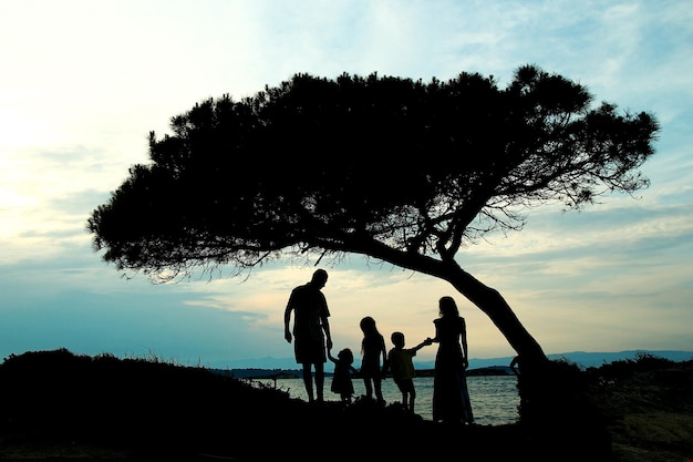 Een gelukkig gezin in de natuur aan zee op reis silhouet