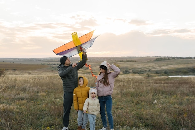 Een gelukkig gezin met kinderen vliegt een vlieger en brengt samen tijd door in de buitenlucht in een natuurreservaat Fijne kindertijd en gezinsvakanties Vrijheid en ruimte