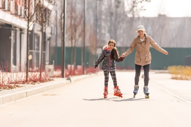 Foto een gelukkig gezin op rolschaatsen, moeder en dochter op rolschaatsen