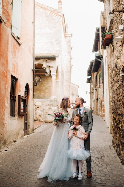 Een gelukkig jong gezin loopt door het oude centrum van Sirmione in Italië.