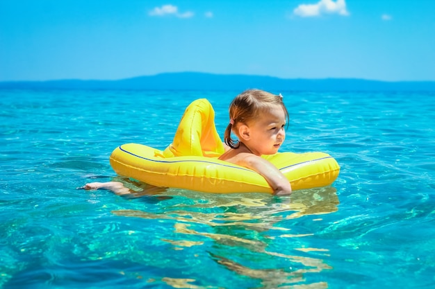 Een gelukkig kind in een vest aan het spelen op zee