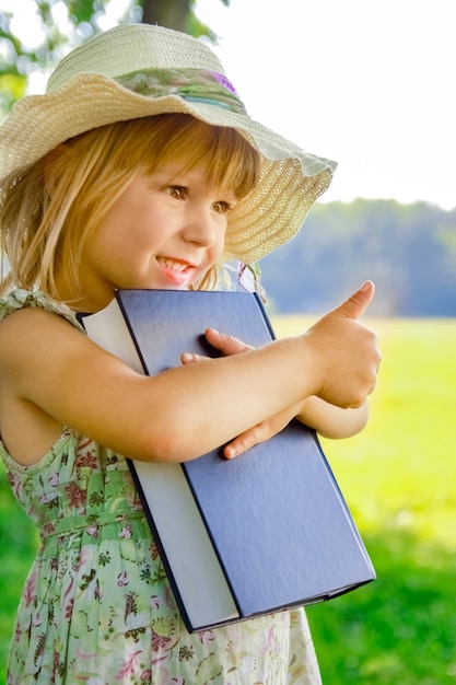 Een gelukkig kind met een boek over de aard van de Bijbel in het Park