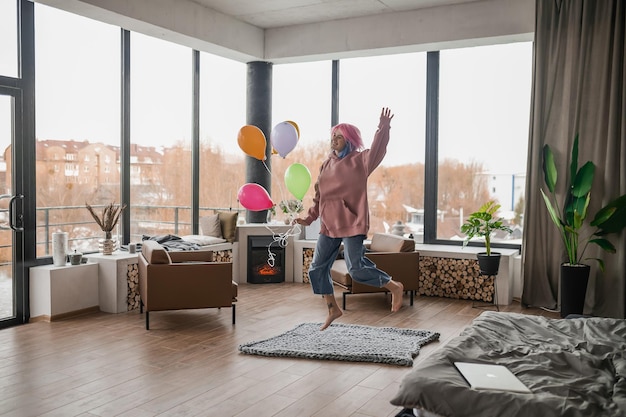 Een gelukkig lachend jong meisje met een bos ballonnen