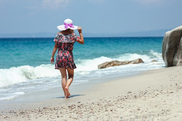 Een gelukkig meisje aan de kust van de zee in reisvakantie