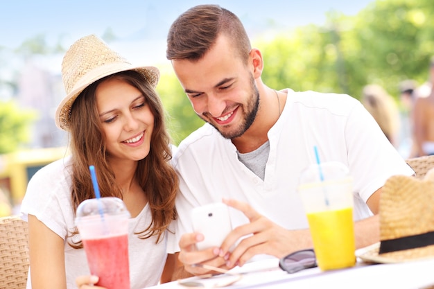 een gelukkig stel dat smartphone gebruikt in een café