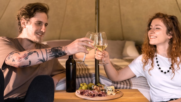 Een gelukkig stel rust in een tent bij glamping wine and food