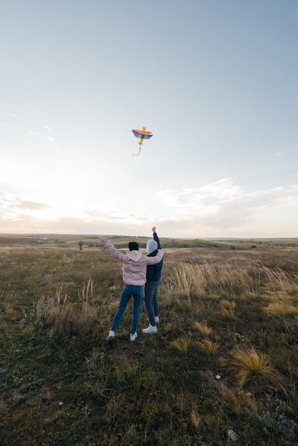 Een gelukkig stel vliegt een vlieger en brengt samen tijd door in de buitenlucht in een natuurreservaat Gelukkige relaties en familievakanties Vrijheid en ruimte