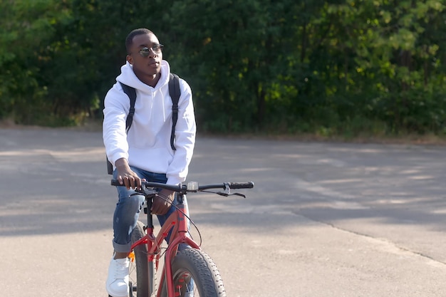 Een gelukkige Afro-Amerikaanse man fietst in een natuurpark Sport en recreatie