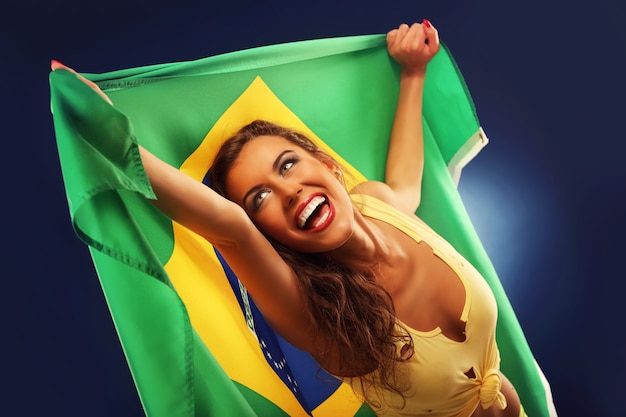 Een gelukkige braziliaanse fan juicht met vlag