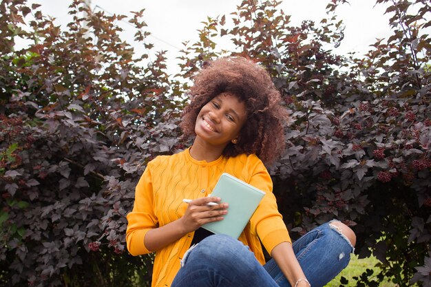 Een gelukkige en jonge Afro-Amerikaanse student in het park