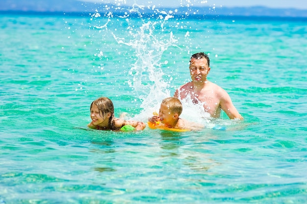 Een gelukkige familie die in het water aan zee speelt