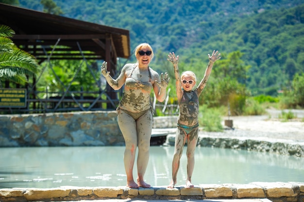 Een gelukkige familie neemt een modderbad in een resort in Turkije. Familiewelzijn in therapeutische modder.