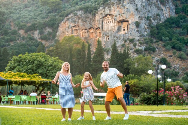 Een gelukkige familie staat op de achtergrond van een berg in de stad dalyan.people in de buurt van lycische graven in turkije.