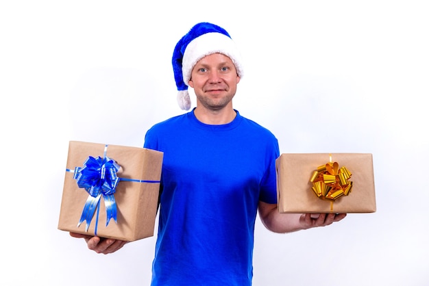 Een gelukkige koerier in een blauw uniform en kerstmuts heeft twee geschenkdozen met strikken