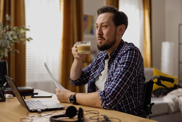 Een gelukkige man van middelbare leeftijd neemt een pauze van zijn werk om koffie te drinken en met zijn kamergenoot te praten